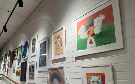 an array of artworks handing along a gallery wall