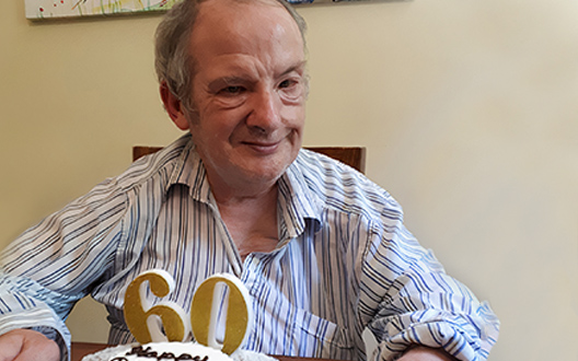 stuart smiling with his 60th birthday cake