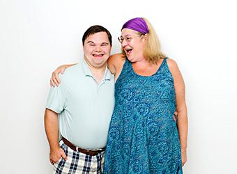 support worker and client laughing arm in arm