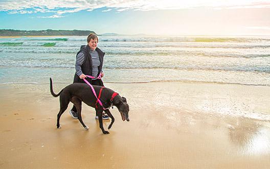 claire walking her family greyhound on the beach