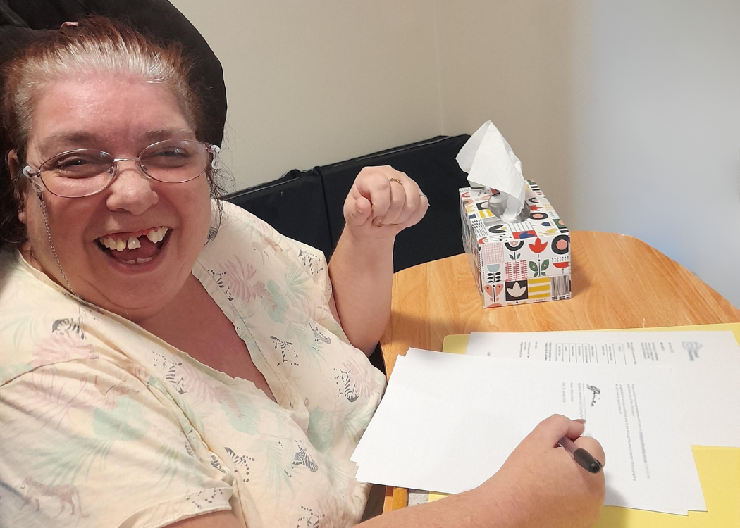 Maree signing her tenancy agreement